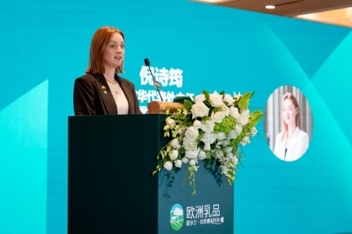 Woman standing behind podium speaking, green Bord Bia background