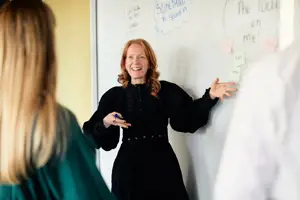 Woman presenting in front of a white board