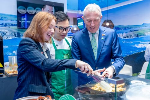 Image of 3 people cooking, with blue sea themed background