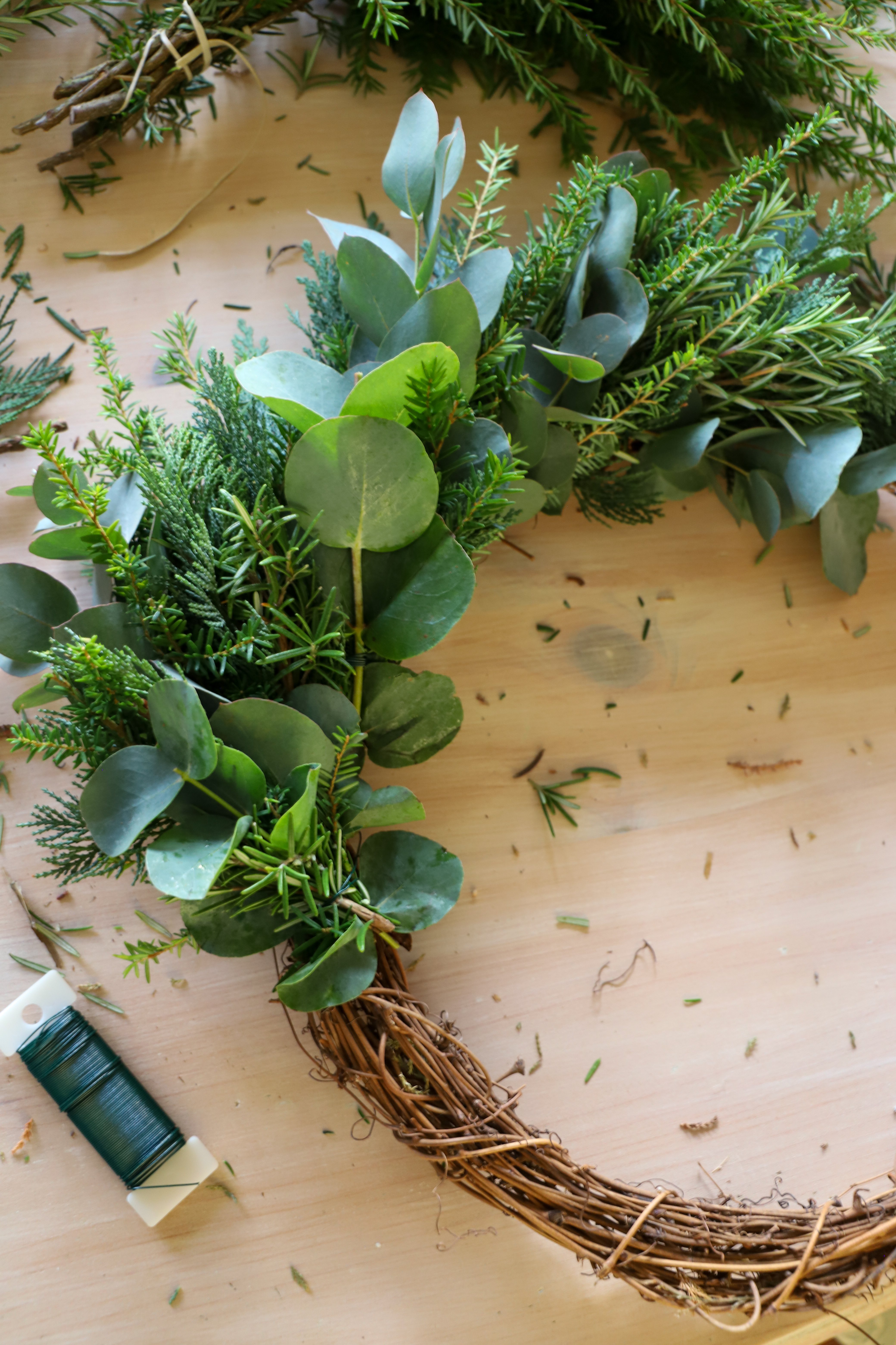 green foliage twisted halfway around wreath base