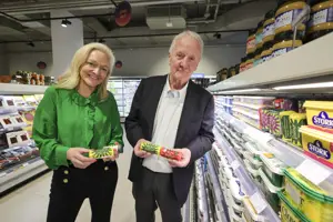 Woman and man standing in supermarket aisle holding butter products