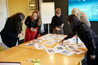 Team brainstorming over a table with multiple images.