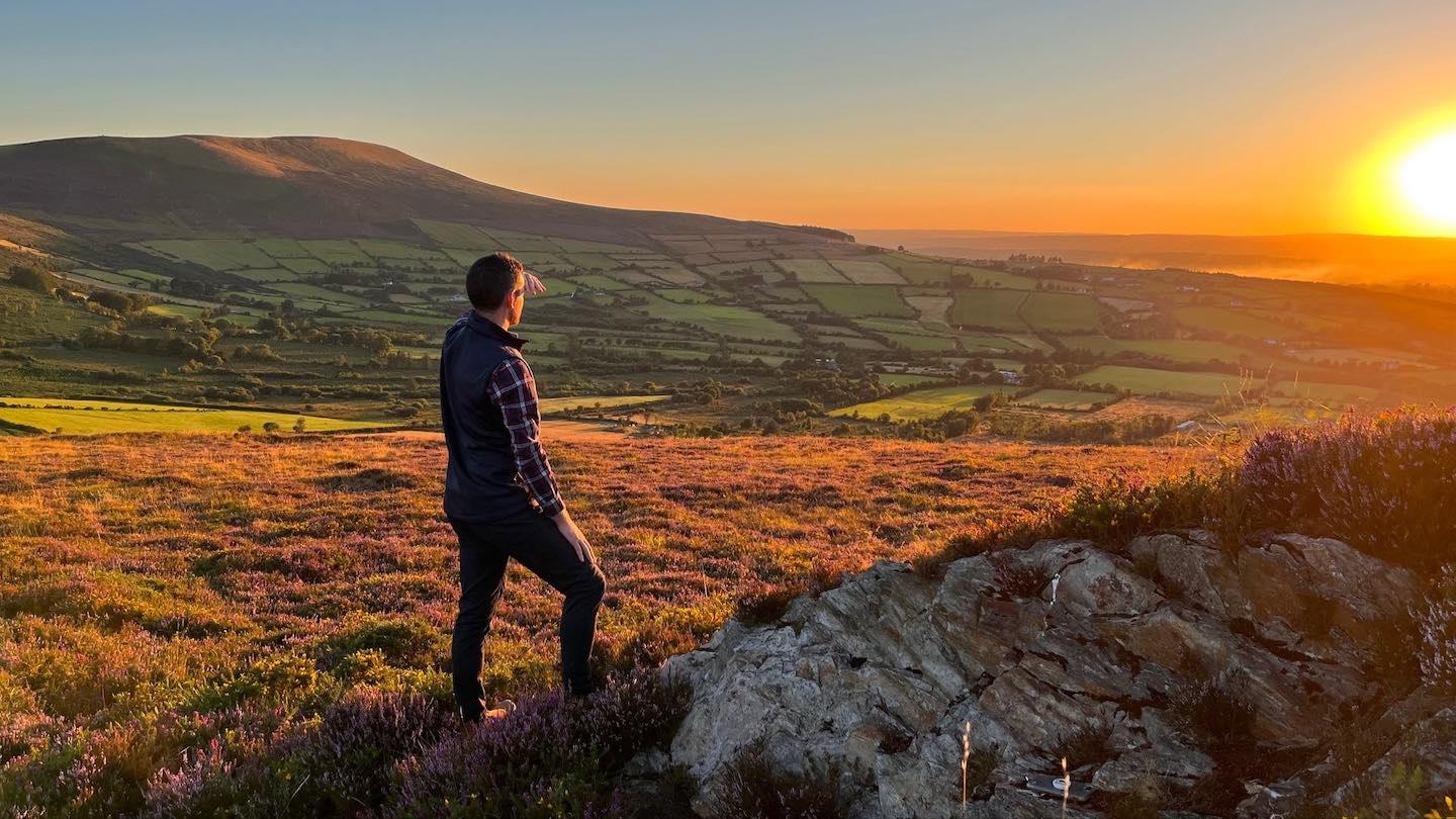 Farmer in field looking into the sunset